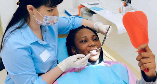 Woman smiling looking in the mirror at the dentist