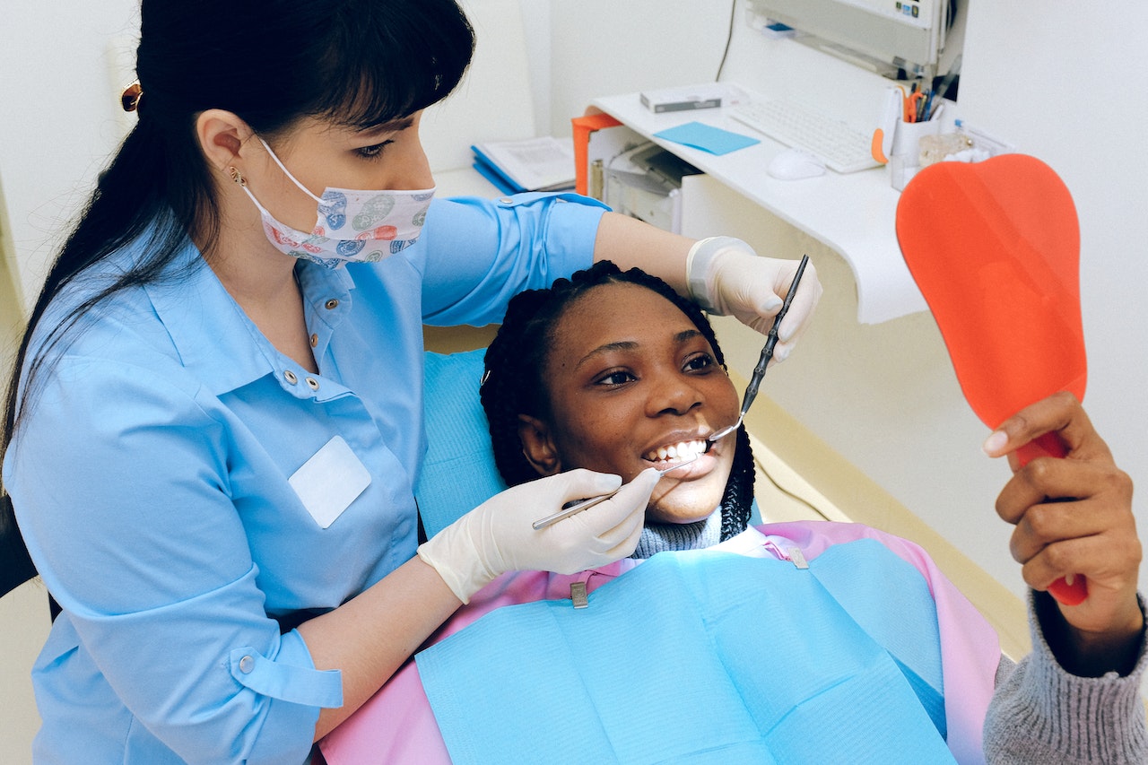 Woman smiling looking in the mirror at the dentist