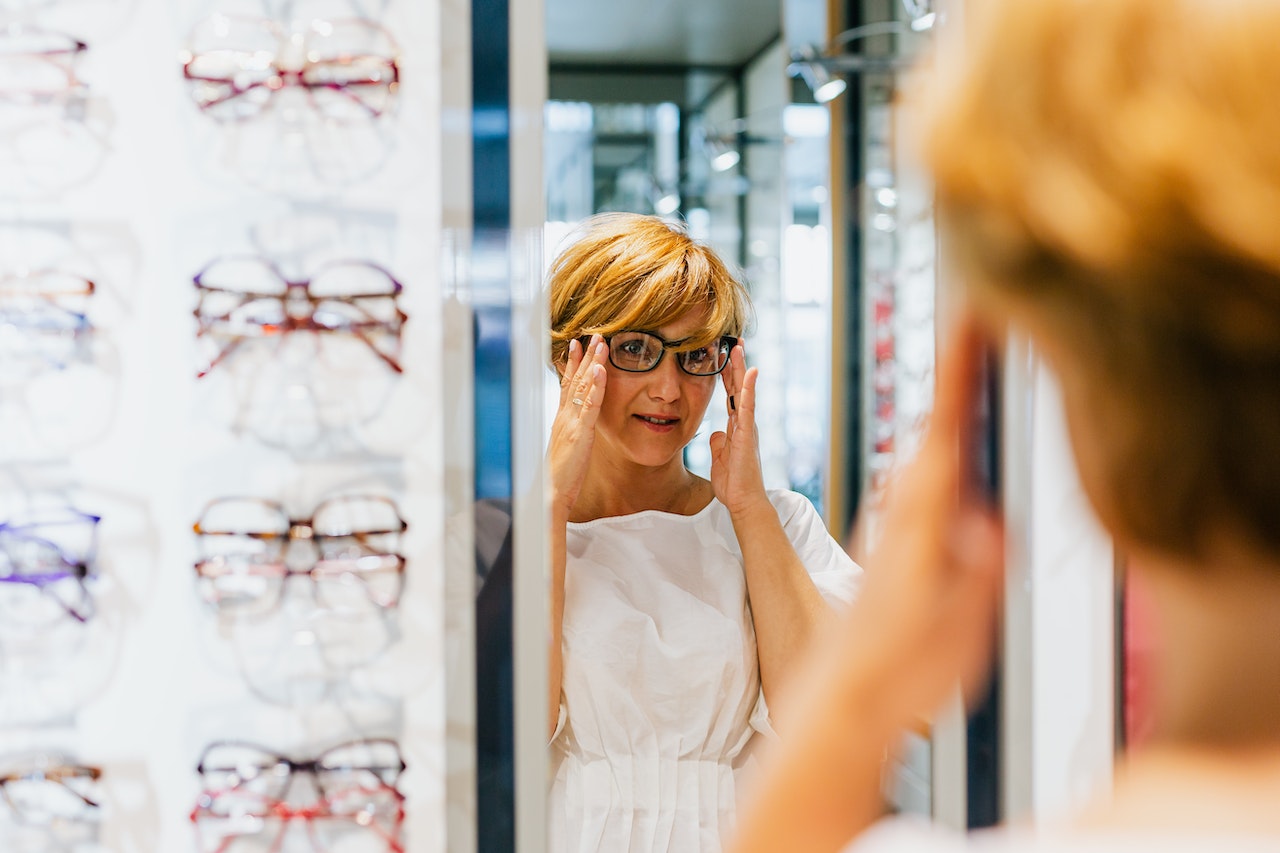 Woman trying on glasses at the opticians