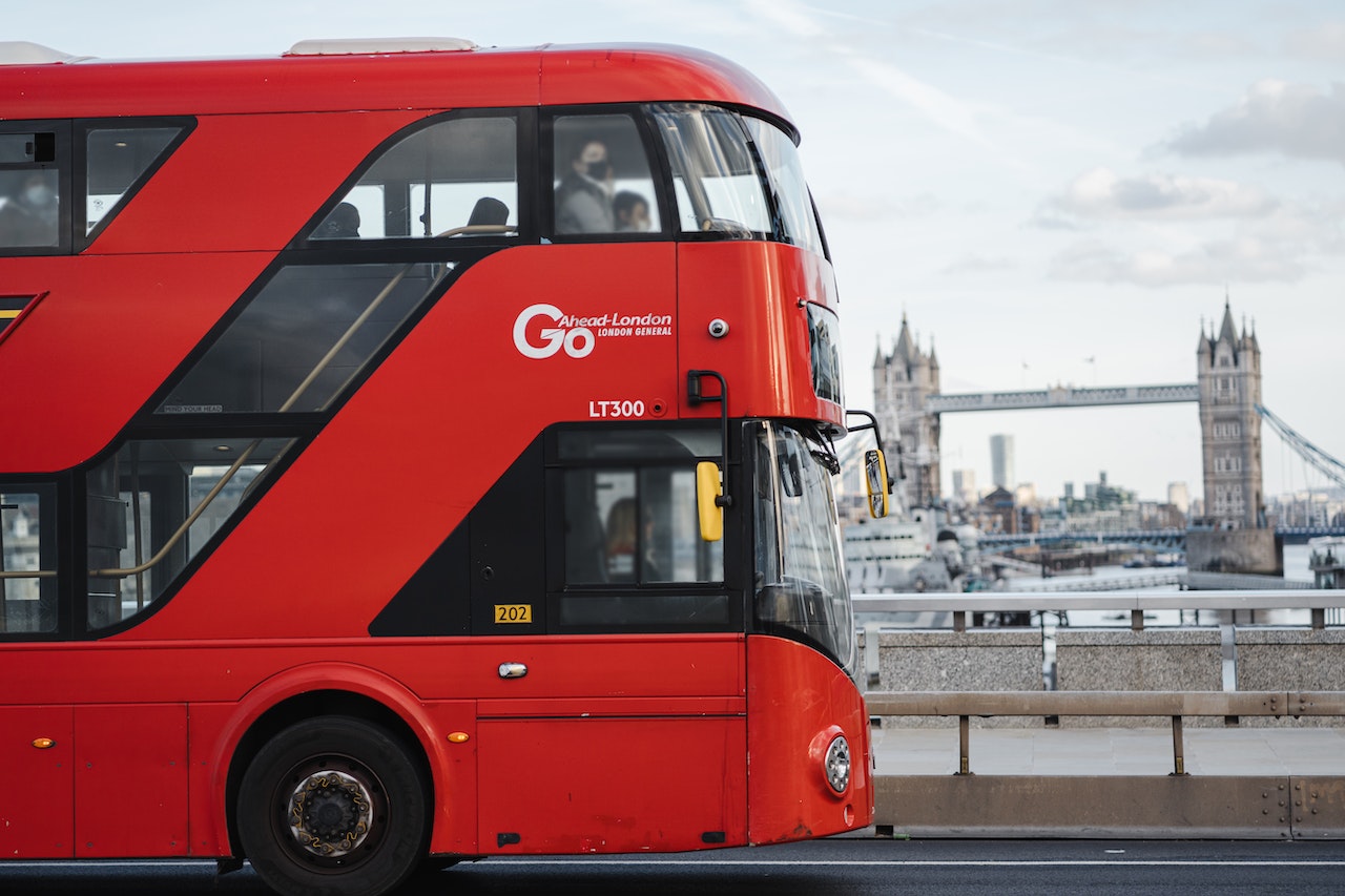 Red London bus driving in front of Tower Bridge