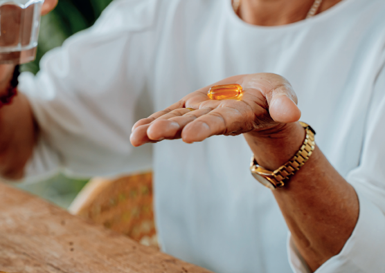 A person holding out a vitamin to to take