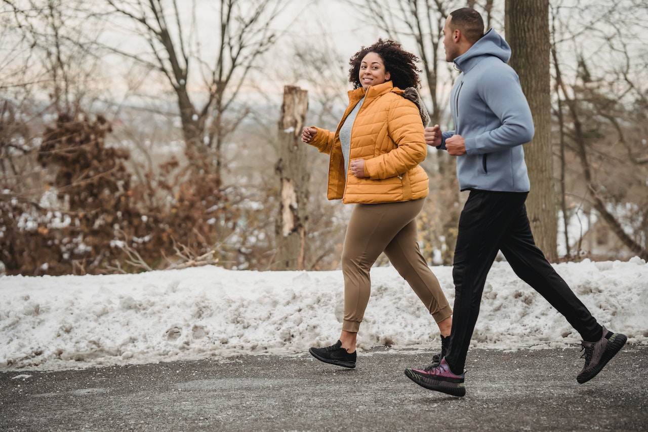 Couple running together in the snow
