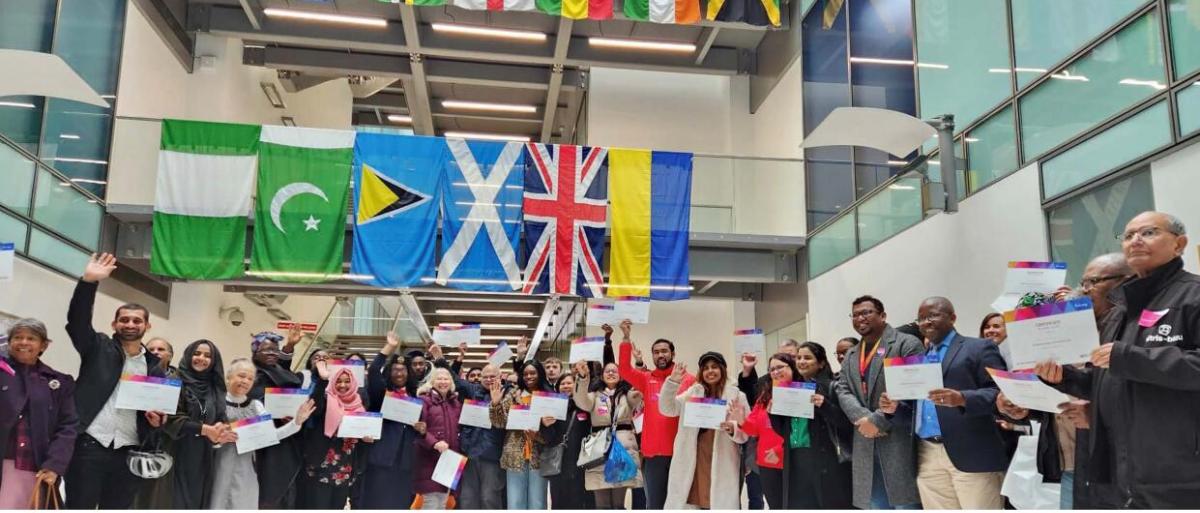 Picture of voluteers with different country flags behinde
