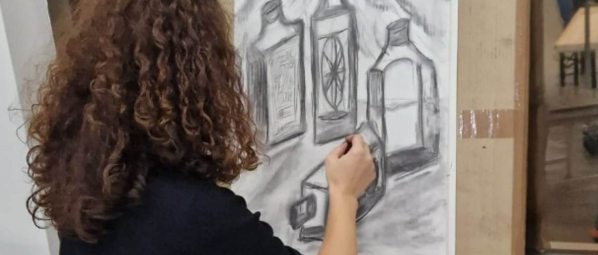 Woman drawing on an easel using charcoal