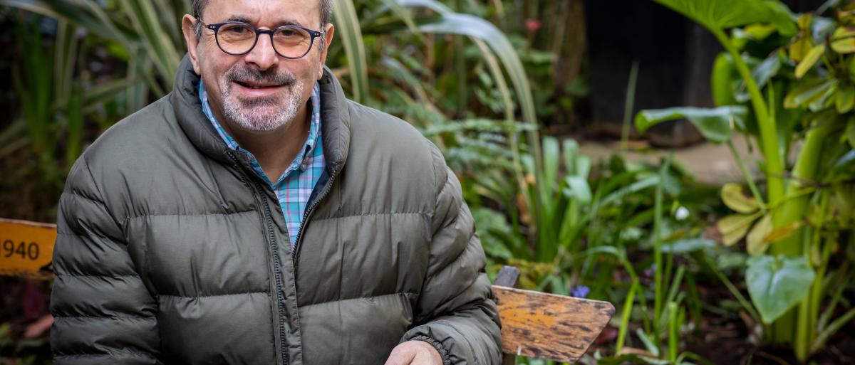 Man sat in his garden with a cup of tea smiling