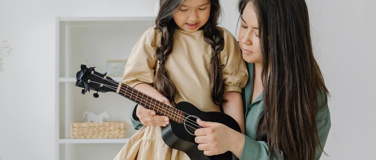 An adult and child playing musical instrument