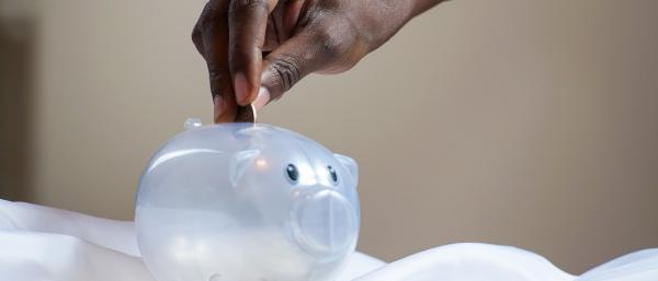 Man putting money into a piggy bank