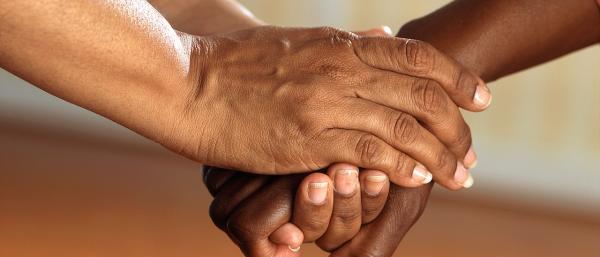 Two people holding hands in a show of support