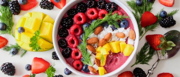 Colourful fruit bowl surrounded by different fruit