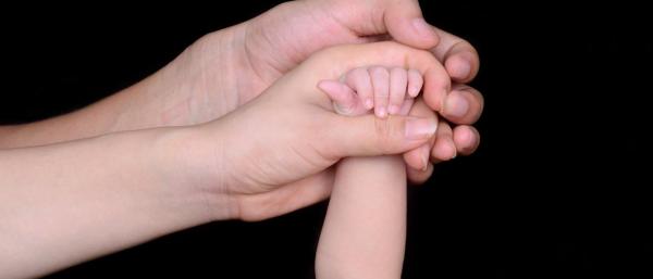 The hands of a child and parents