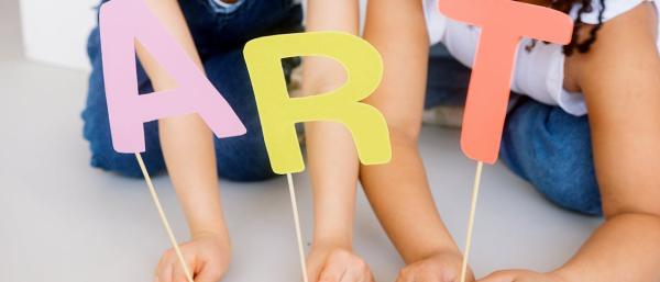Art written out with cardboard held by 3 kids