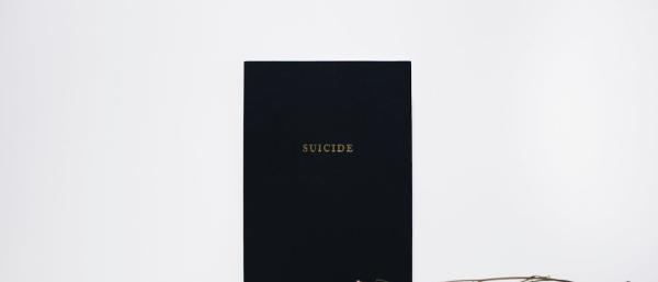 Suicide written on a blackboard with pink flowers