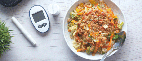 Healthy food plated with a blood sugar testing machine