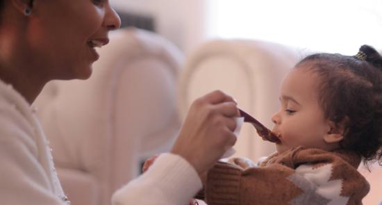 Mum feeding a child with a spoon