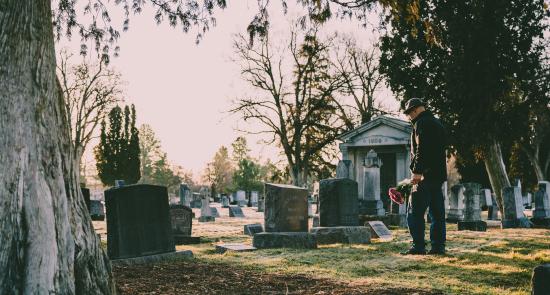 Man bringing flowers to a gravestone