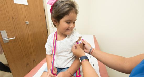 Girl having a plaster on her arm after a vaccine