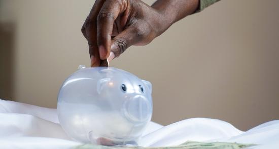 Man putting money into a piggy bank