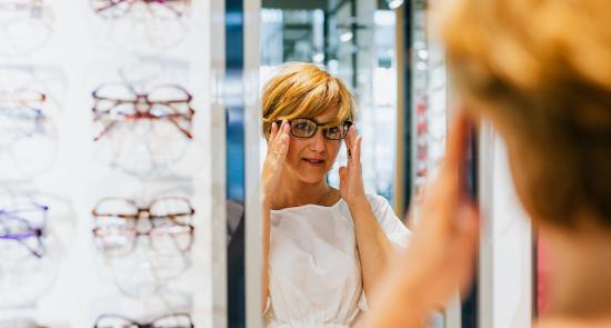 Woman trying on glasses at the opticians