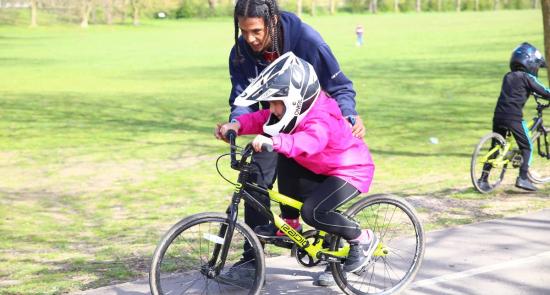 Woman helping a child to ride a bike