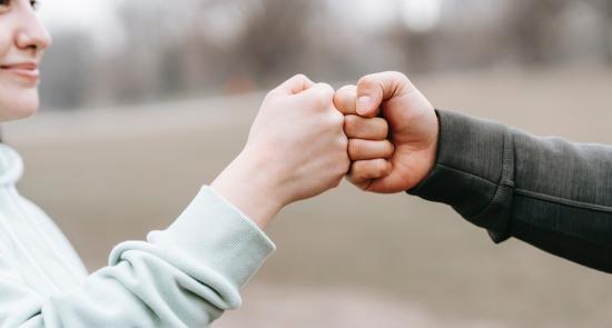 Two people fist bumping