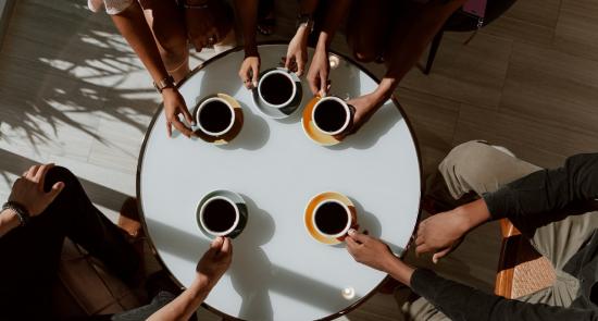 People sitting around a table having a coffee together