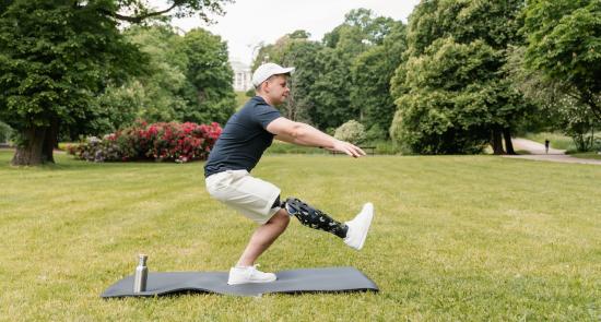 Man is doing an exercise activity on a mat in a park