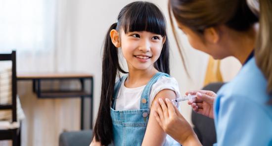 A child is getting immunised by a nurse