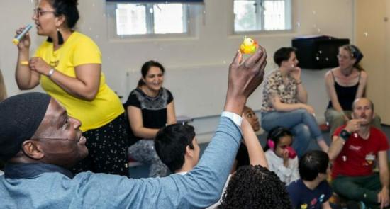 Artist leading a creative workshop with children and their parents