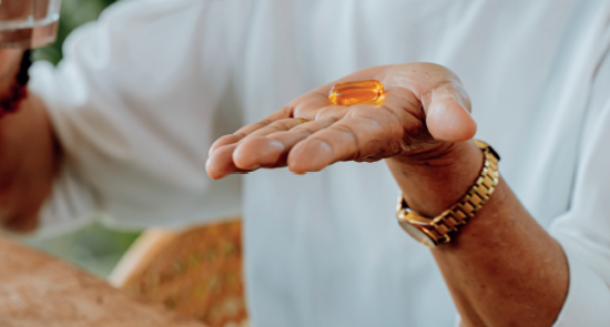 A person holding out a vitamin to to take