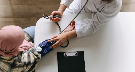 A female doctor checking a patients blood pressure