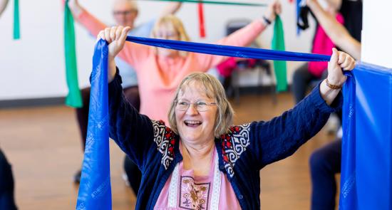 Older woman doing chair based exercise