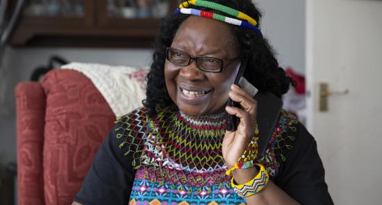 Woman sitting on an armchair on the phone smiling