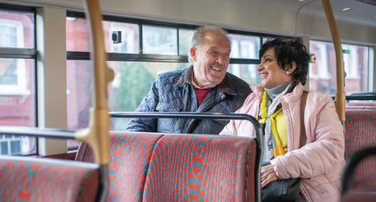 Man and woman sitting together on a London bus chatting