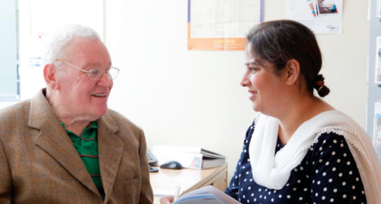 An elderly man talking to a woman