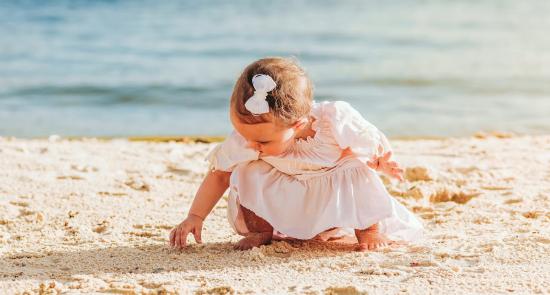 A toddler playing on the beach